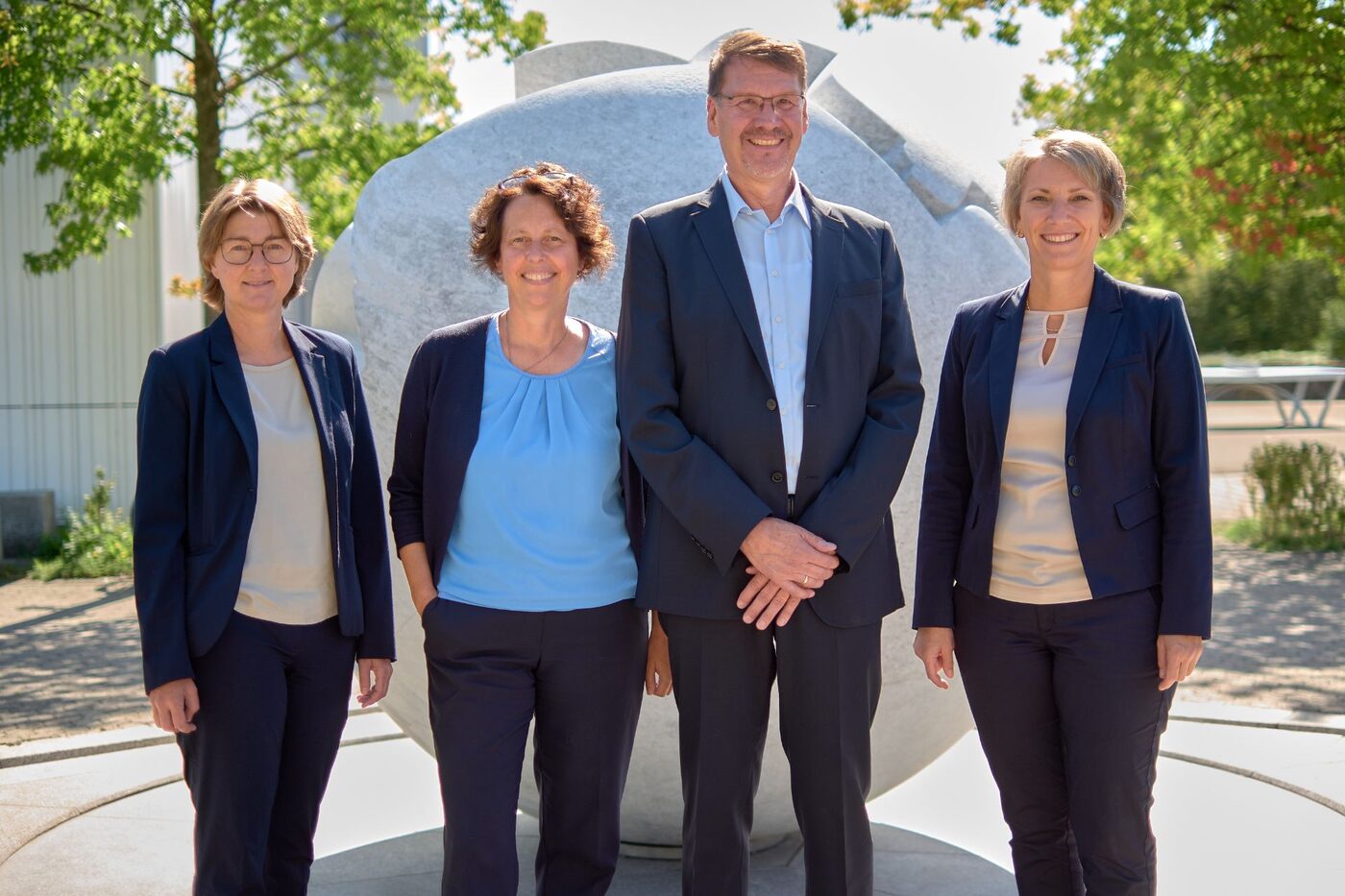 Die Schulleitung des Regiomontanus-Gymnasiums vor der Skulptur im Schulhof